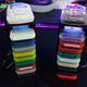 18 colorful memory cards are stacked vertically in two custom-made PlayStation memory card holders. A PocketStation sits atop each.